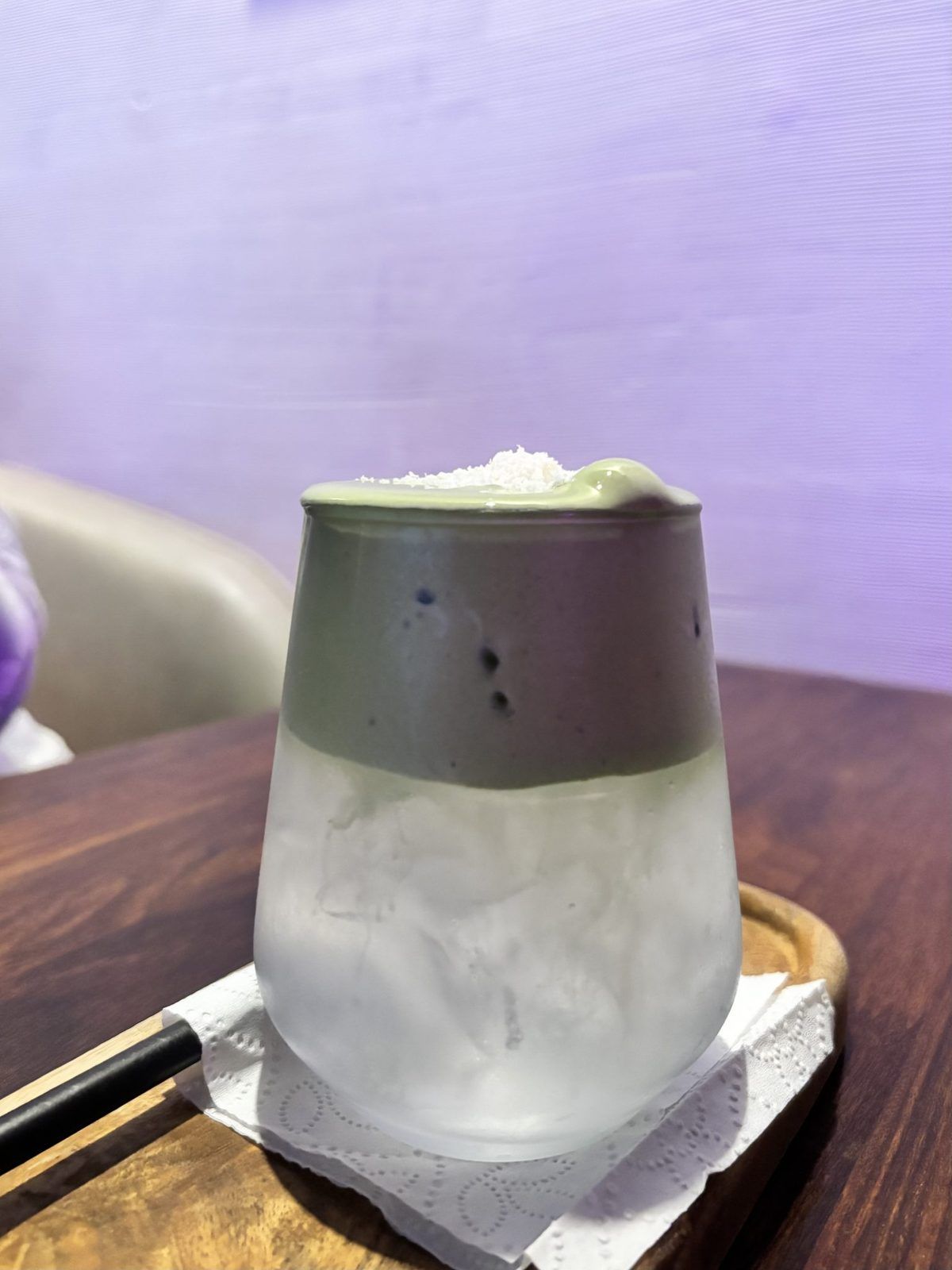 A glass of iced green matcha latte with milk.