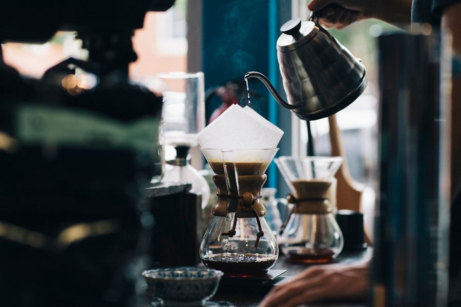 A pour-over coffee dripper brewing into a glass carafe.